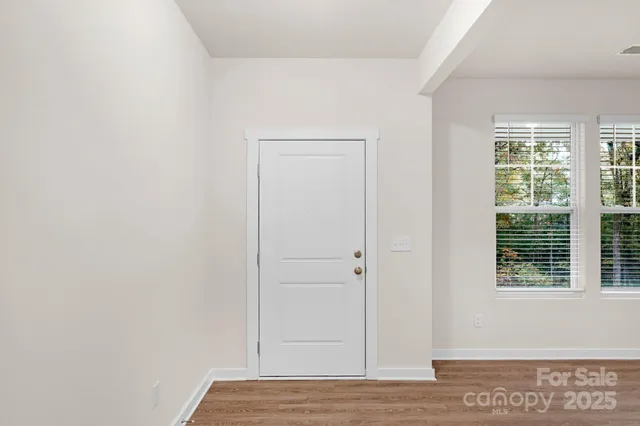 a view of hallway with window and hardwood floor