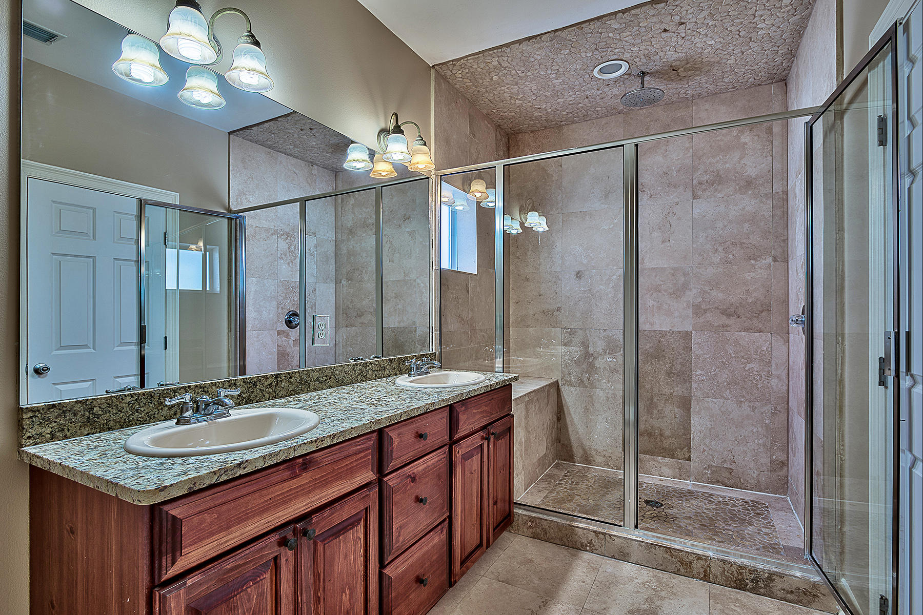 239 Inverrary Drive Destin, FL 32541 - Photo 6 of 20 a bathroom with a granite countertop shower sink vanity and mirror