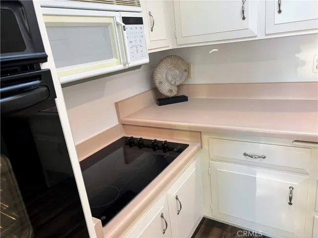 a kitchen with granite countertop white cabinets and white appliances