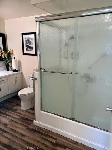 a bathroom with a glass shower door and a window
