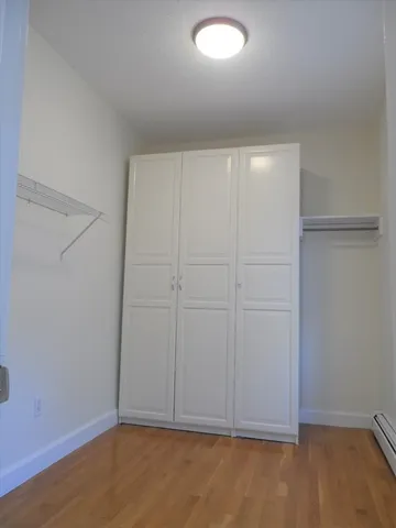 an empty room with wooden floor and closet in room