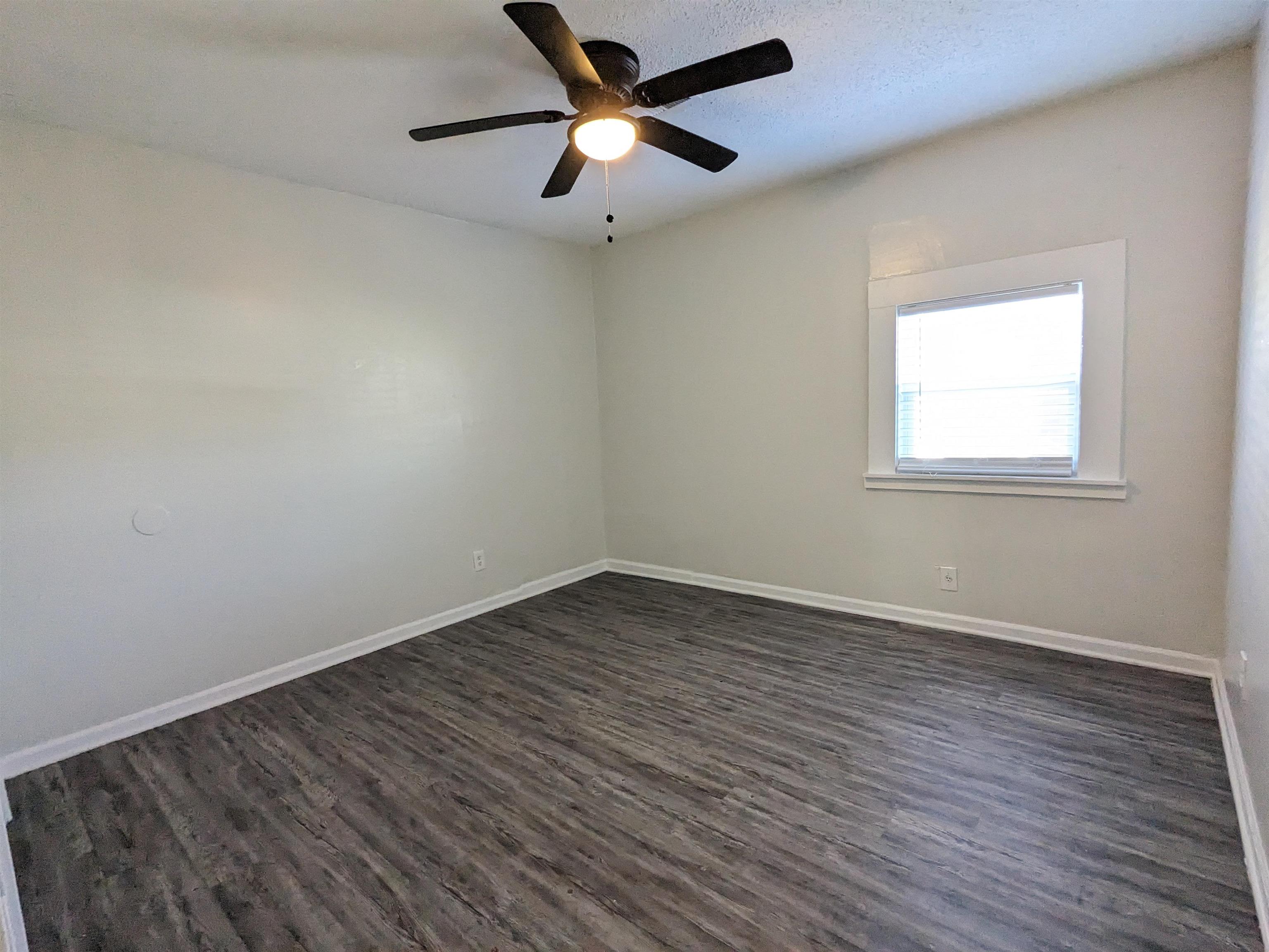 4499 Range Line Road Memphis, TN 38127 - Photo 4 of 10 wooden floor in an empty room with a window