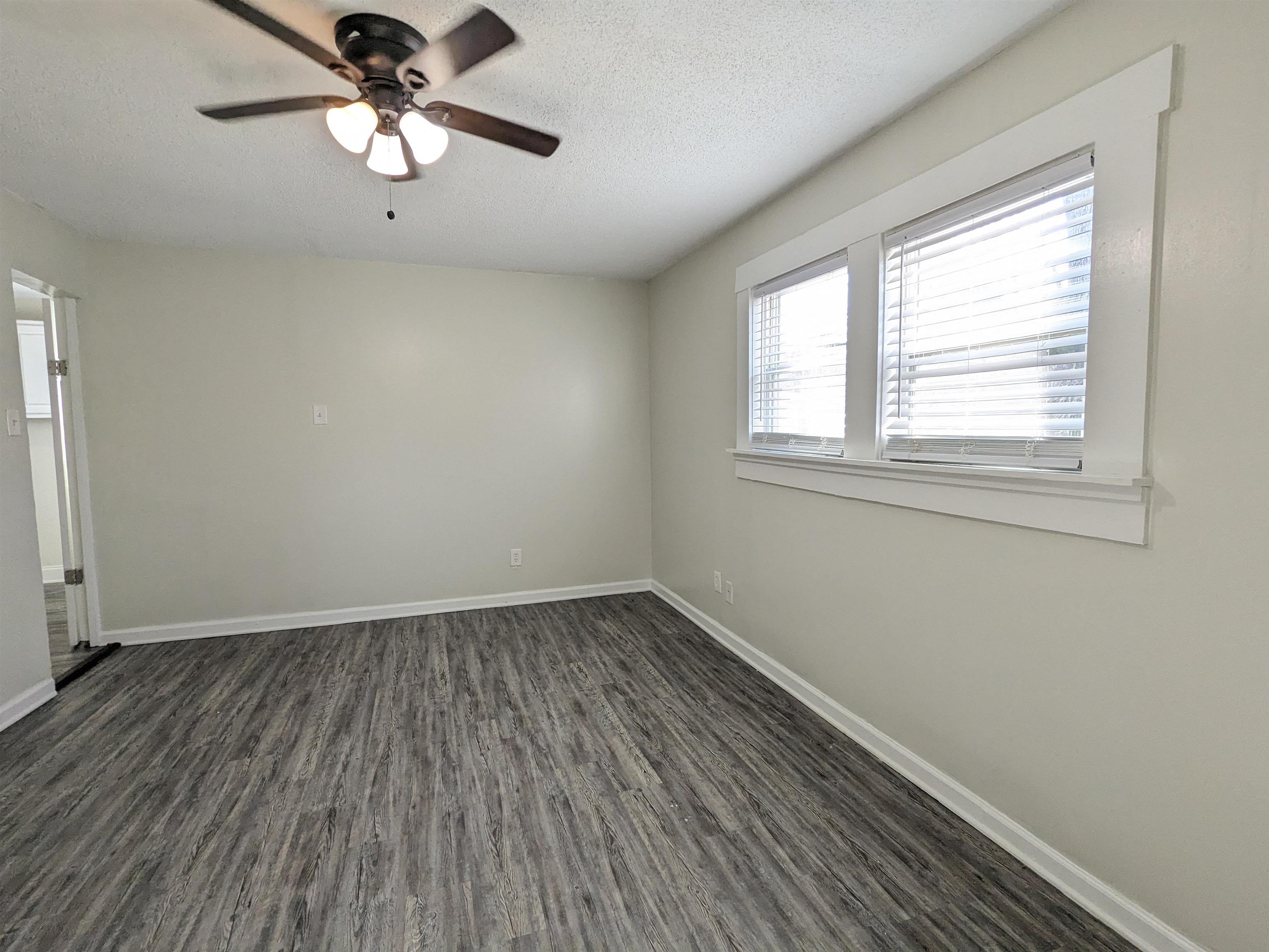 4499 Range Line Road Memphis, TN 38127 - Photo 5 of 10 an empty room with wooden floor fan and windows