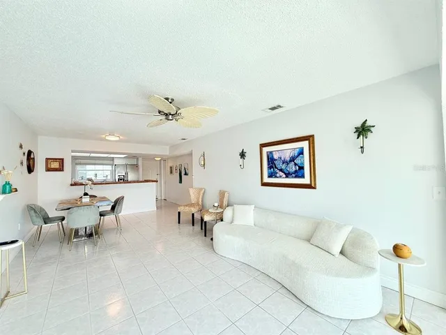 a living room with furniture and a view of kitchen