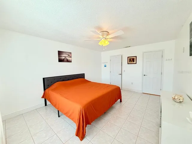 a bedroom with a bed and painting on the wall