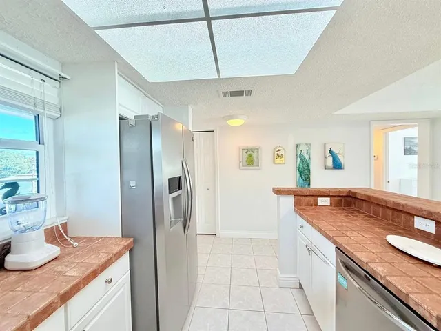 a kitchen with granite countertop a sink and refrigerator