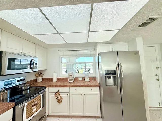 a kitchen with stainless steel appliances granite countertop a refrigerator a stove and a sink