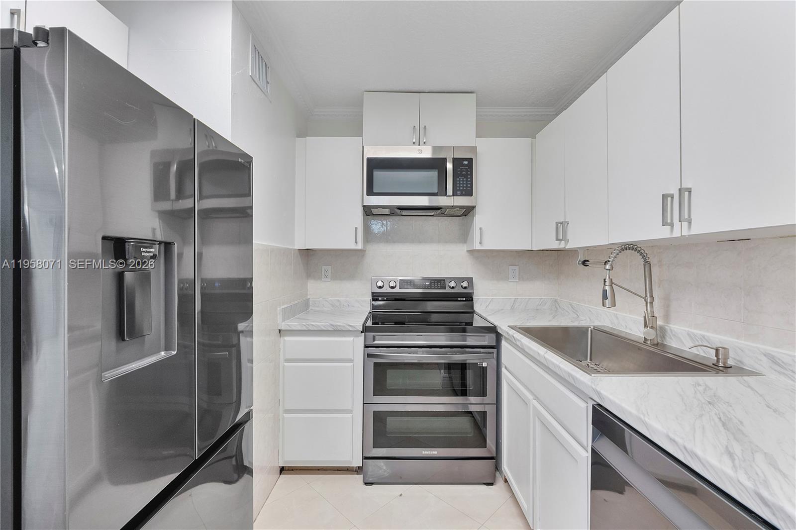 8050 Northwest 8th Street, Unit 1203 Miami, FL 33126 - Photo 3 of 14 a kitchen with stainless steel appliances granite countertop a sink stove and refrigerator