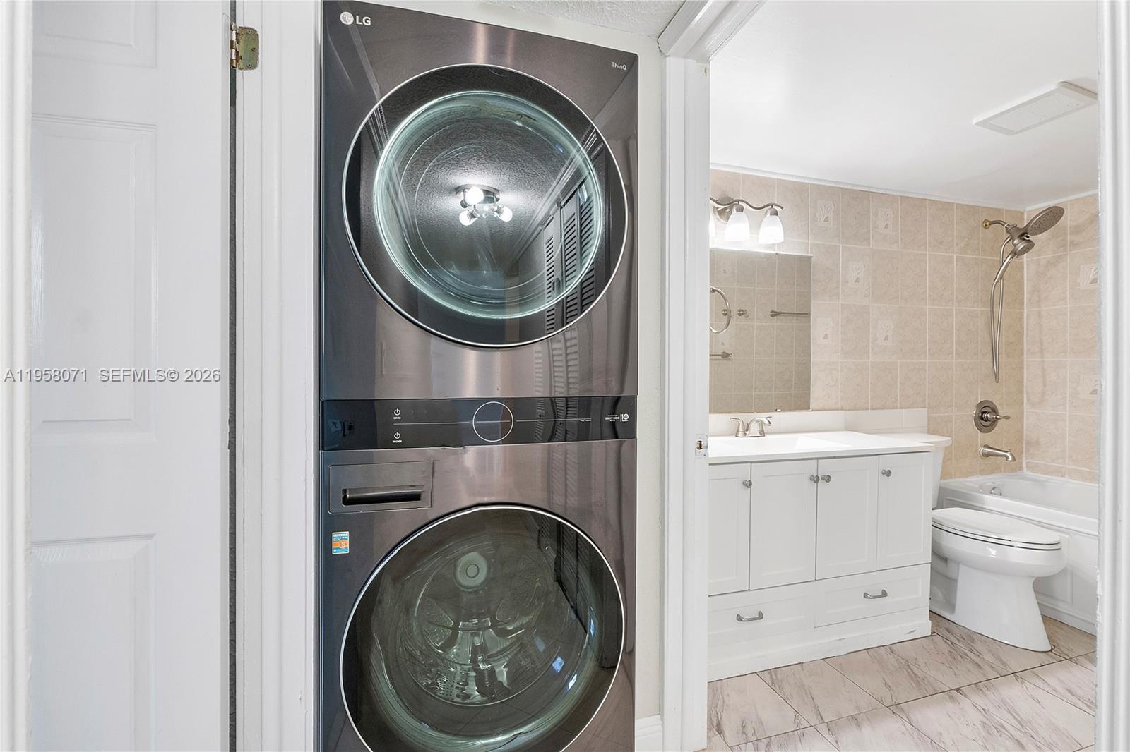 8050 Northwest 8th Street, Unit 1203 Miami, FL 33126 - Photo 6 of 14 a view of a bathroom with washing machine and washing machine