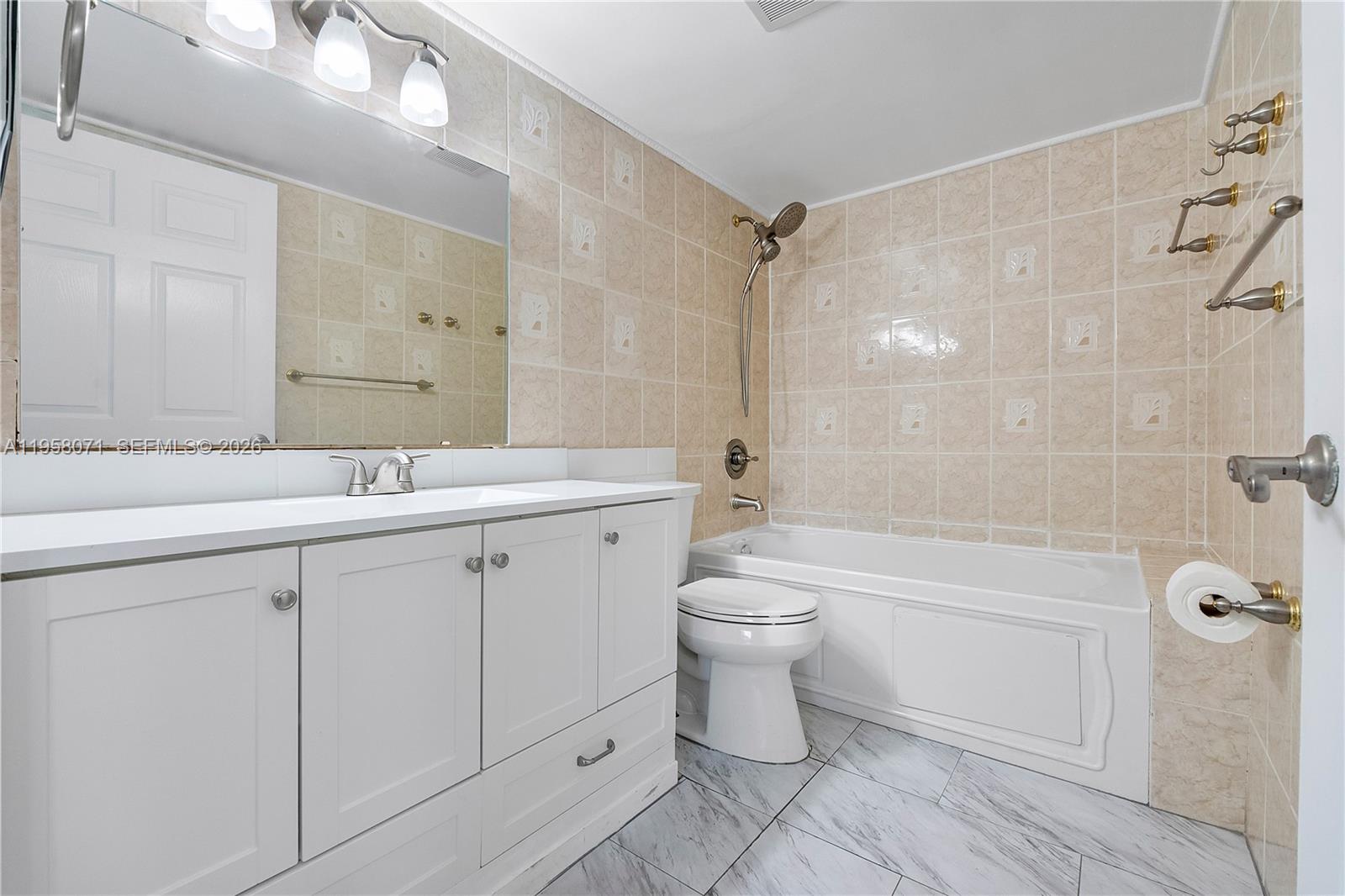 8050 Northwest 8th Street, Unit 1203 Miami, FL 33126 - Photo 7 of 14 a bathroom with a double vanity sink toilet and shower