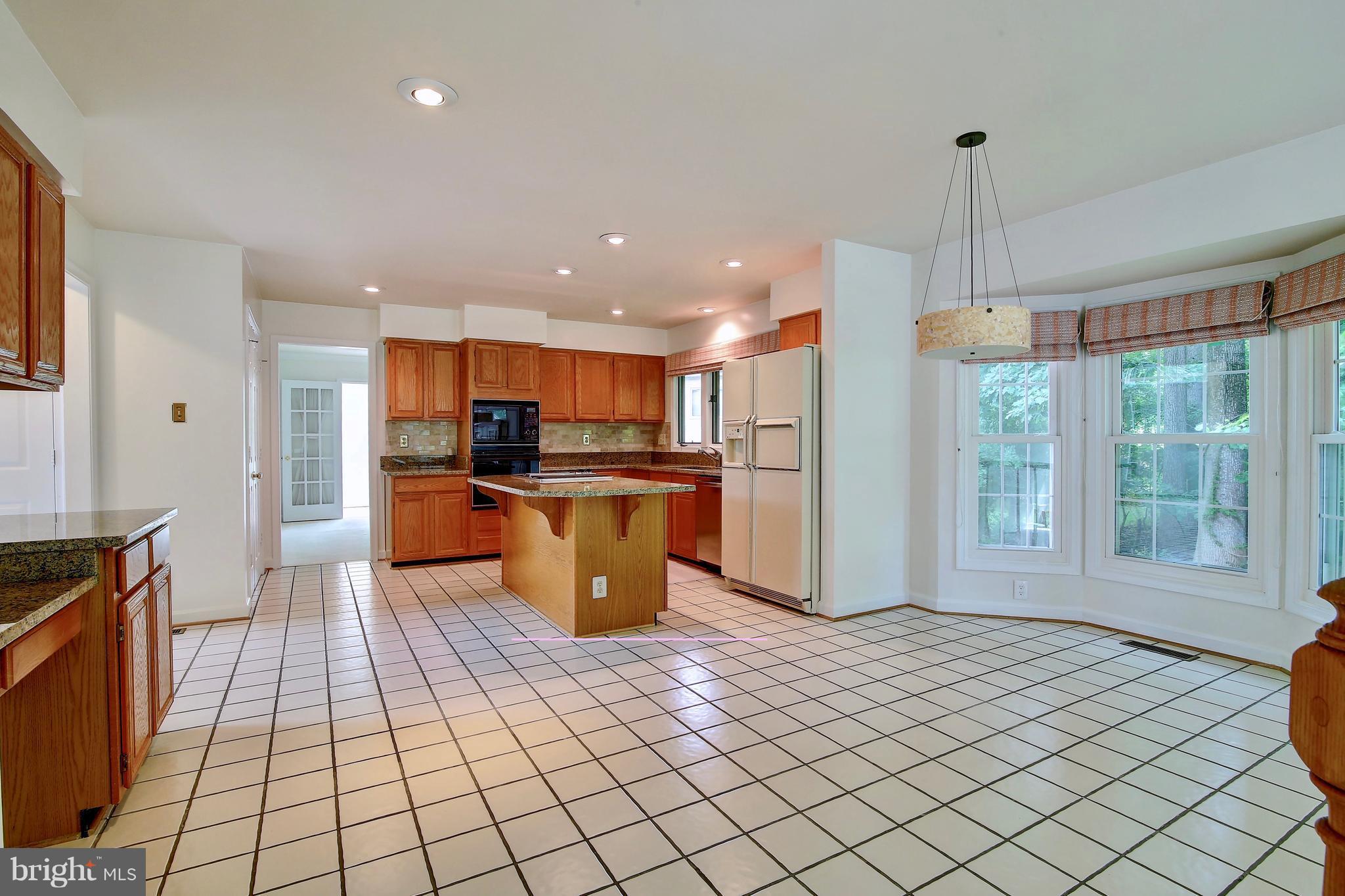 14515 Cutstone Way Silver Spring, MD 20905 - Photo 12 of 29 a large kitchen with stainless steel appliances kitchen island granite countertop a refrigerator and a stove top oven