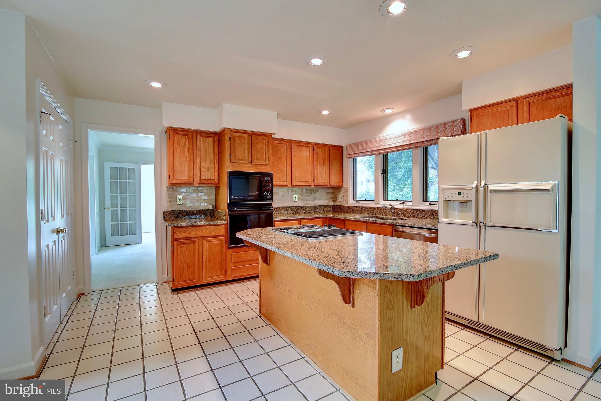 14515 Cutstone Way Silver Spring, MD 20905 - Photo 13 of 29 a kitchen with stainless steel appliances granite countertop a refrigerator a sink and a stove