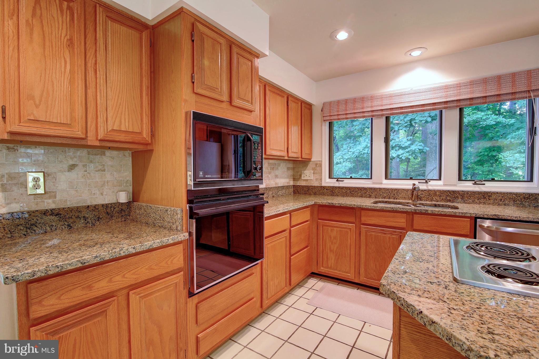 14515 Cutstone Way Silver Spring, MD 20905 - Photo 15 of 29 a kitchen with granite countertop a sink stove and cabinets