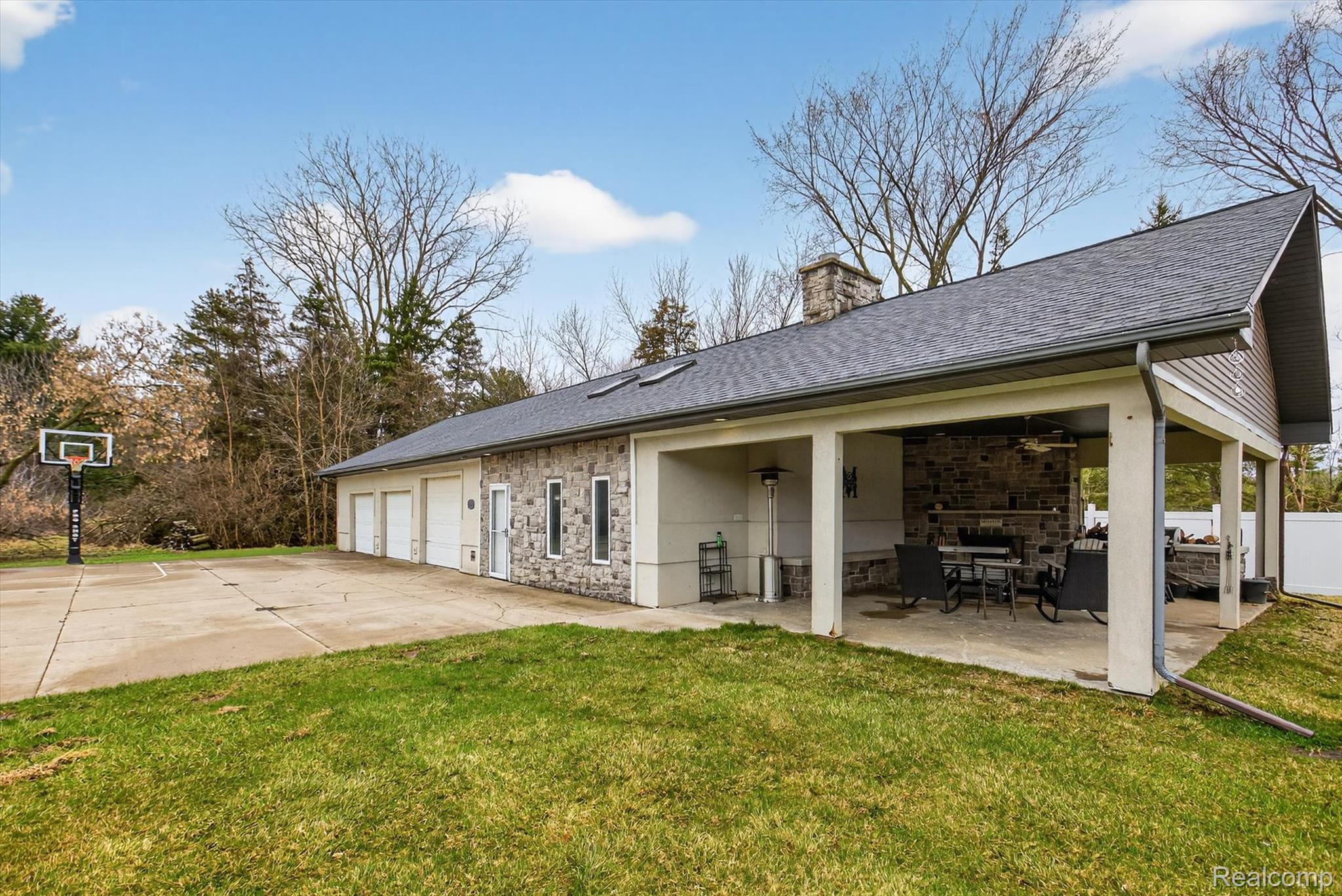 552 North McKinley Road Flushing, MI 48433 - Photo 77 of 98 Rear view of house with stone siding, a lawn, a patio, and a chimney