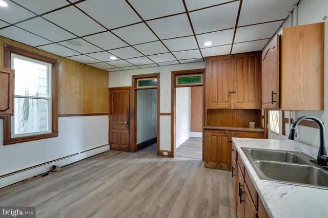 a kitchen with stainless steel appliances granite countertop a sink a refrigerator cabinets and wooden floor