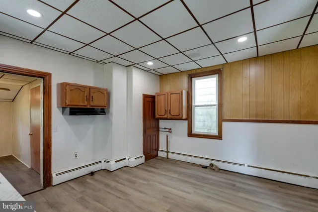 a view of a livingroom with wooden floor and a ceiling fan