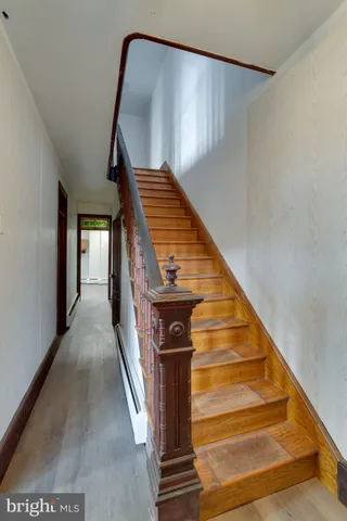 a view of staircase with railing and white walls