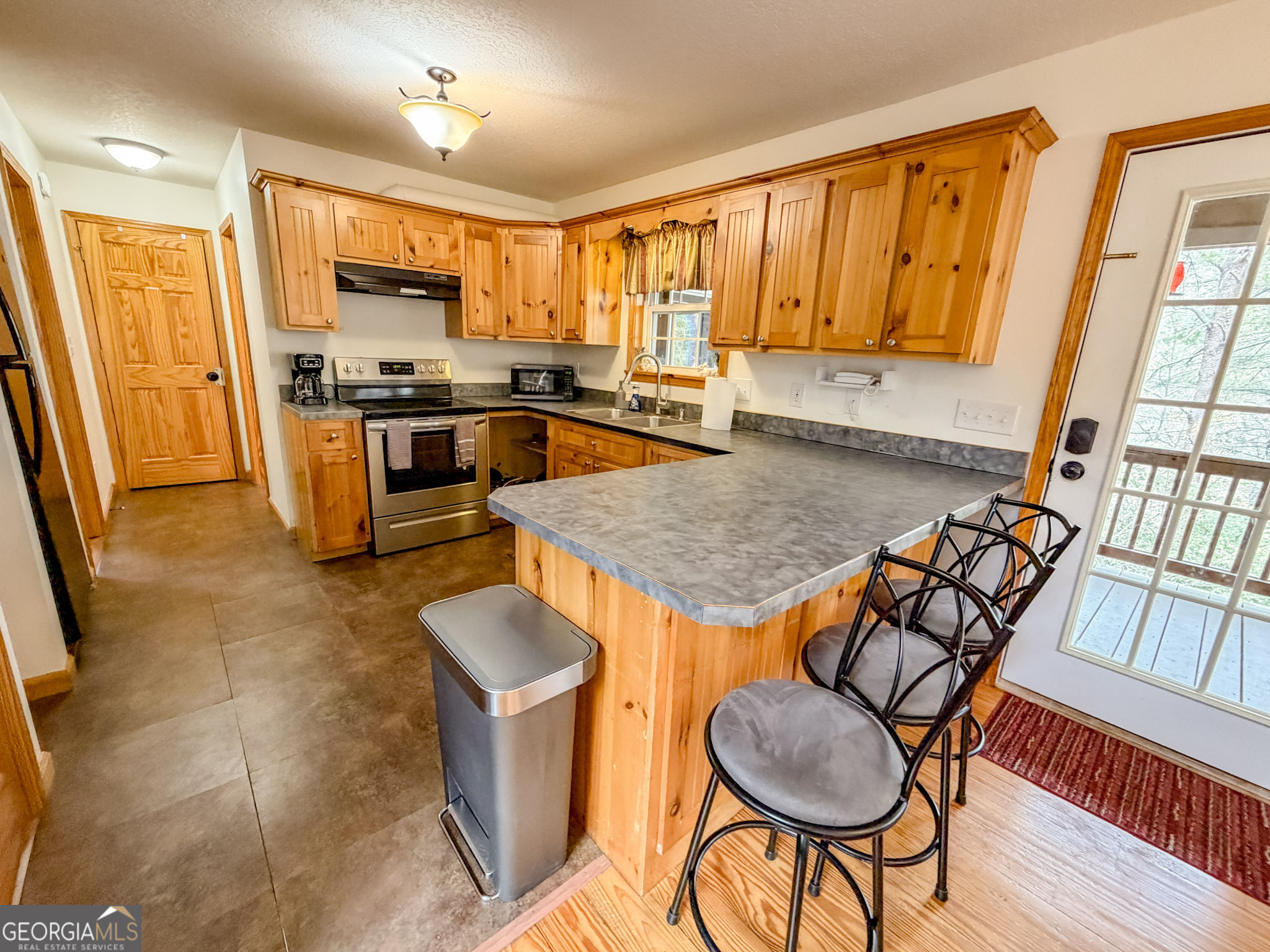 703 Zeppelin Strasse Helen, GA 30545 - Photo 10 of 28 a kitchen with granite countertop kitchen island stainless steel appliances a stove a sink a microwave and dining table
