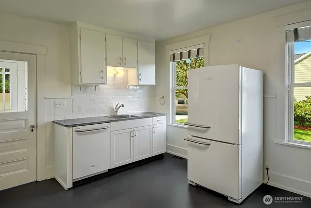 a kitchen with appliances a sink and a window