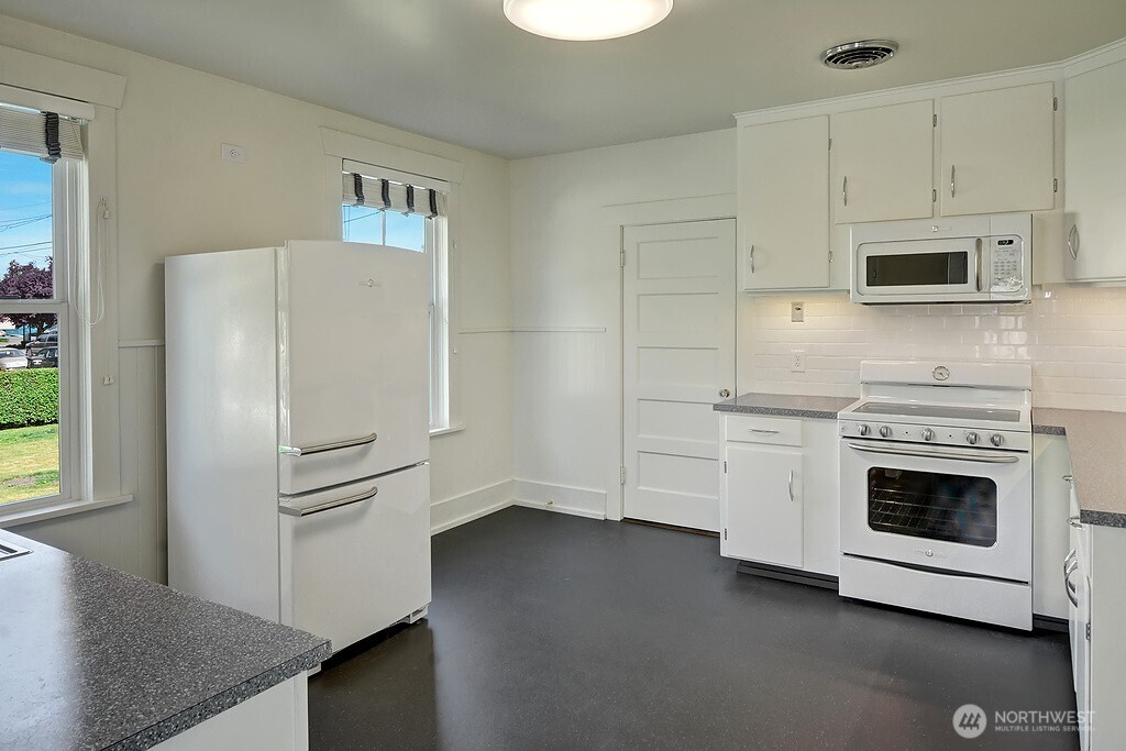 5403 Maynard Avenue South Seattle, WA 98108 - Photo 10 of 26 a kitchen with stainless steel appliances white cabinets and a refrigerator