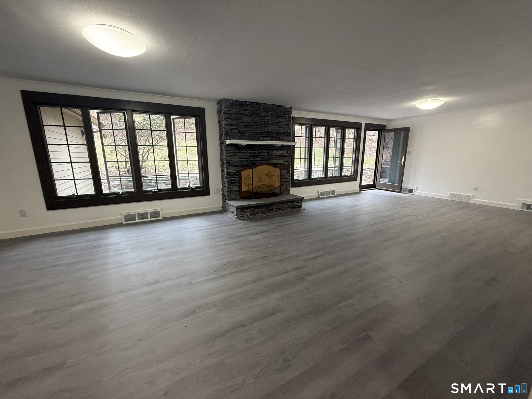 110 Town Woods Road Lyme, CT 06371 - Photo 11 of 37 an empty room with wooden floor and a fireplace