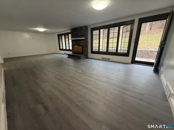an empty room with wooden floor and windows