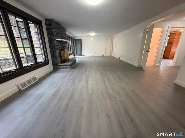 an empty room with wooden floor and windows