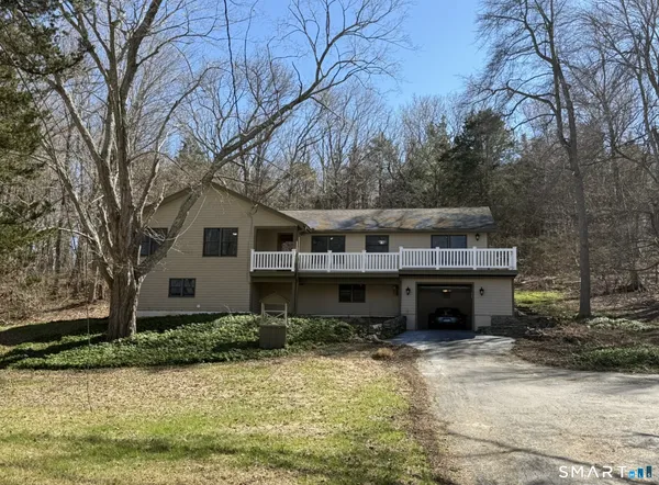 a front view of house with yard and trees in the background