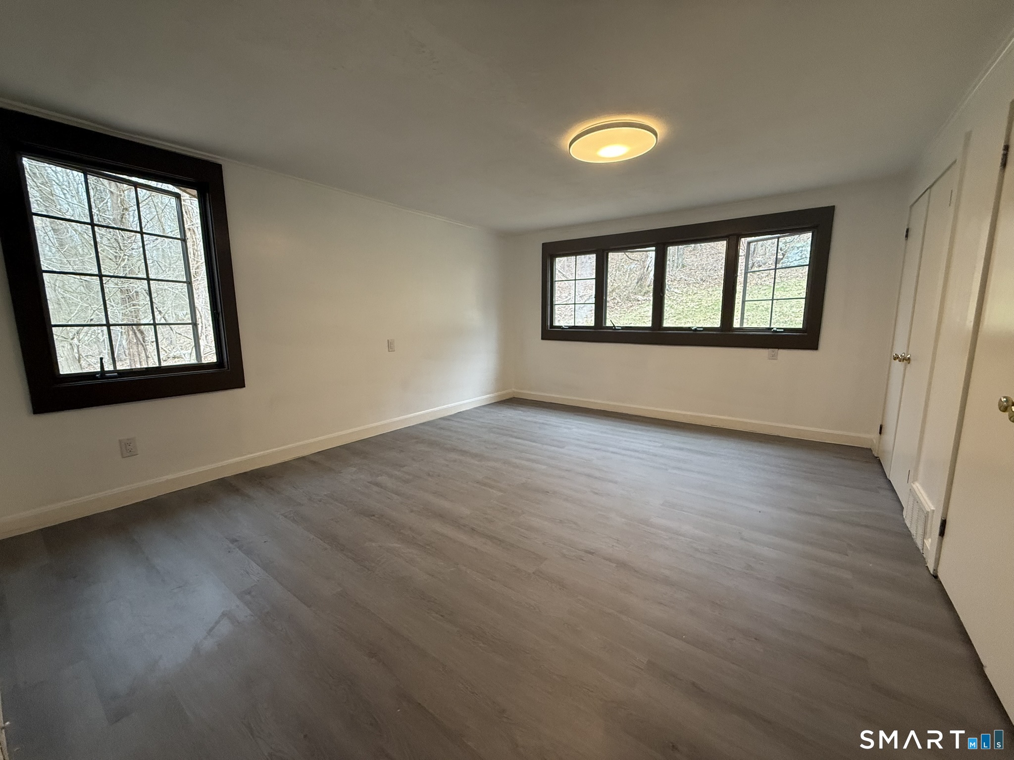 110 Town Woods Road Lyme, CT 06371 - Photo 23 of 37 an empty room with wooden floor and windows