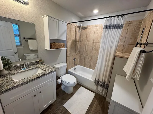a bathroom with a granite countertop sink toilet and shower