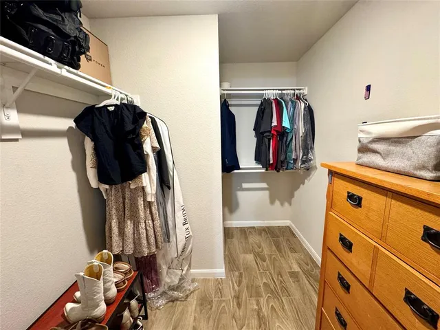 a view of walk in closet with clothes and shoes