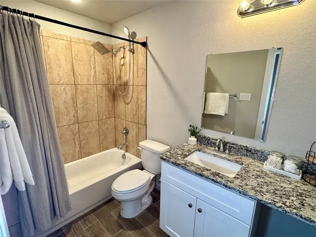 a bathroom with a granite countertop sink toilet and shower