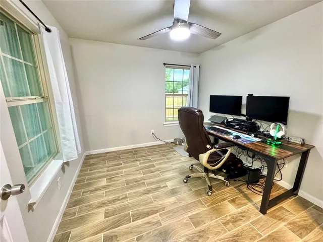 a workspace with wooden floor and a window