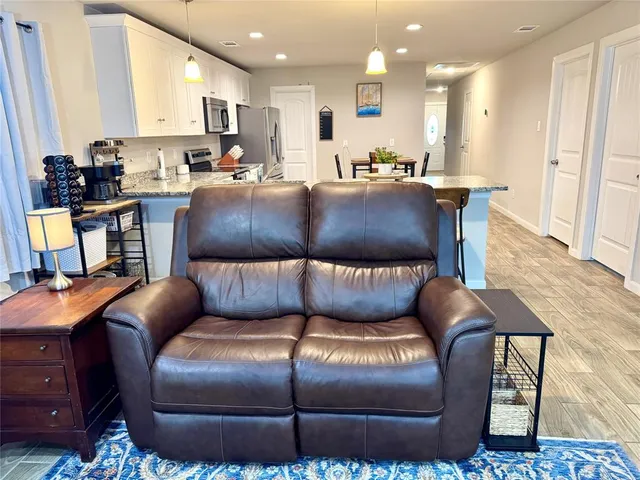 a living room with furniture a wooden floor and a chandelier