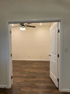a view of an empty room with wooden floor and closet