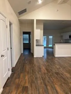 a view of a hallway with wooden floor and cabinet