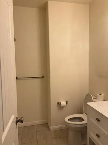 a bathroom with a granite countertop toilet and a sink