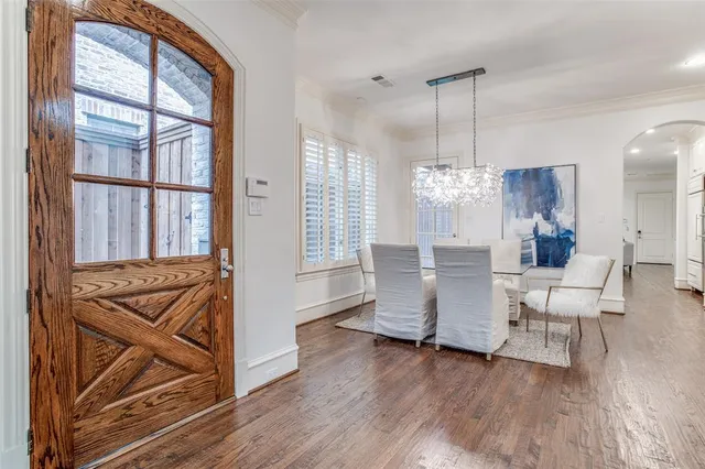 a dining room with furniture a chandelier and wooden floor