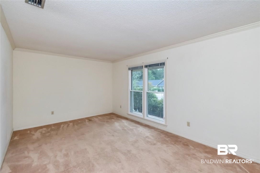 6109 Timberly Road North Mobile, AL 36609 - Photo 12 of 26 Carpeted empty room featuring a textured ceiling and ornamental molding