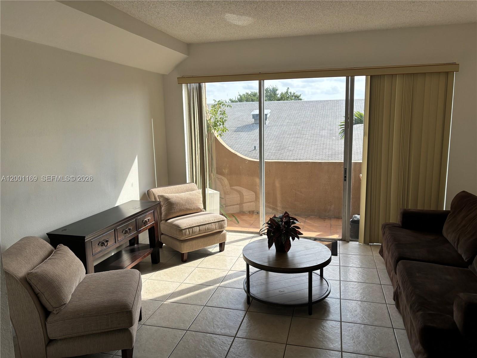 10900 Southwest 104th Street, Unit 303 Miami, FL 33176 - Photo 2 of 40 a living room with furniture and a large window