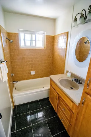 a bathroom with a tub sink and mirror