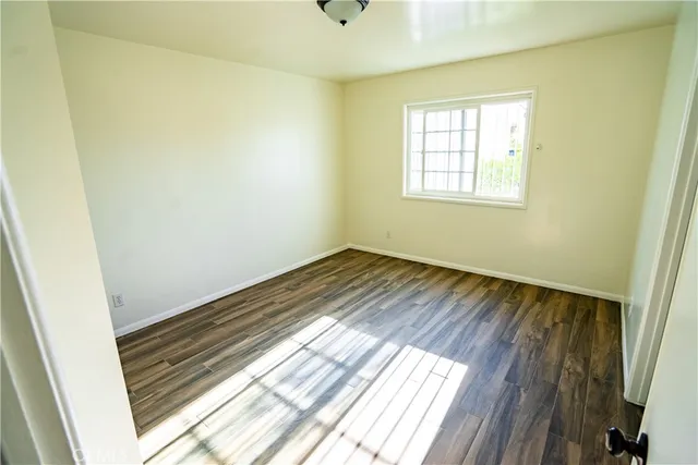 a view of a room with wooden floor and window