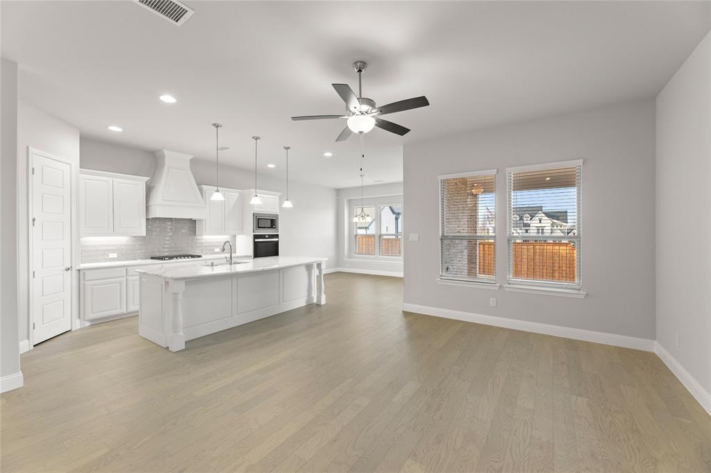 3539 Helios Lane Corinth, TX 76208 - Photo 14 of 33 a large white kitchen with kitchen island a large counter top space a sink stainless steel appliances and cabinets