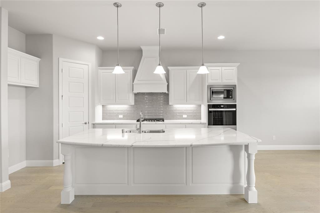 3539 Helios Lane Corinth, TX 76208 - Photo 15 of 33 a view of a kitchen with kitchen island a sink stainless steel appliances and a counter top space