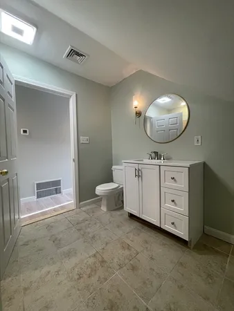 a bathroom with a toilet sink and mirror