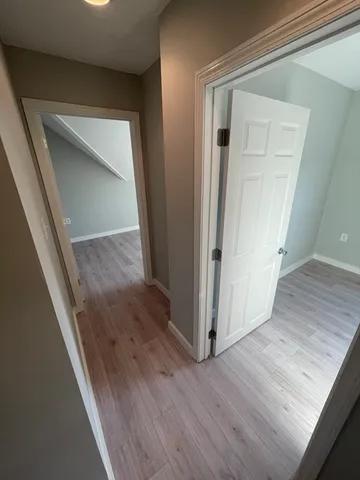 a view of a hallway with wooden floor