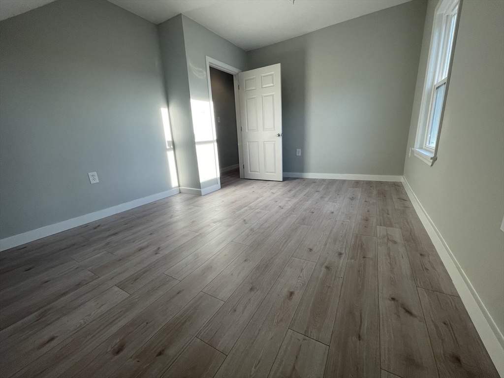 97 Cottage Street, Unit 2 Northbridge, MA 01588 - Photo 10 of 14 a view of an empty room with wooden floor and windows