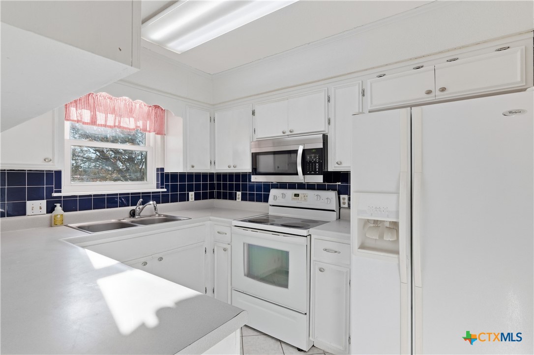 151 Hillside Street Seguin, TX 78155 - Photo 8 of 33 a kitchen with stainless steel appliances granite countertop a stove a sink and a refrigerator