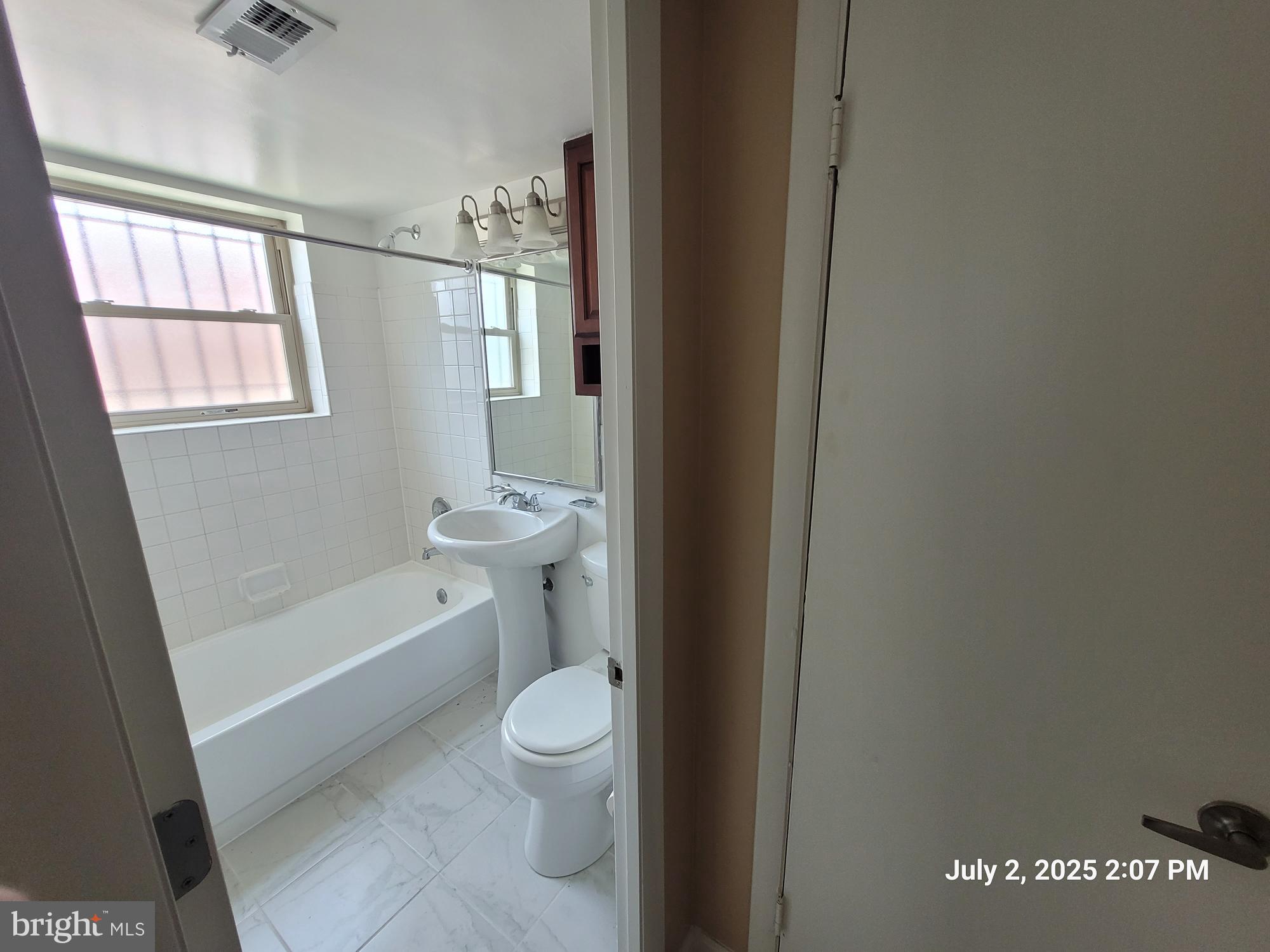 2644 Birney Place Southeast, Unit 102 Washington, DC 20020 - Photo 23 of 36 a bathroom with a toilet a sink and a window