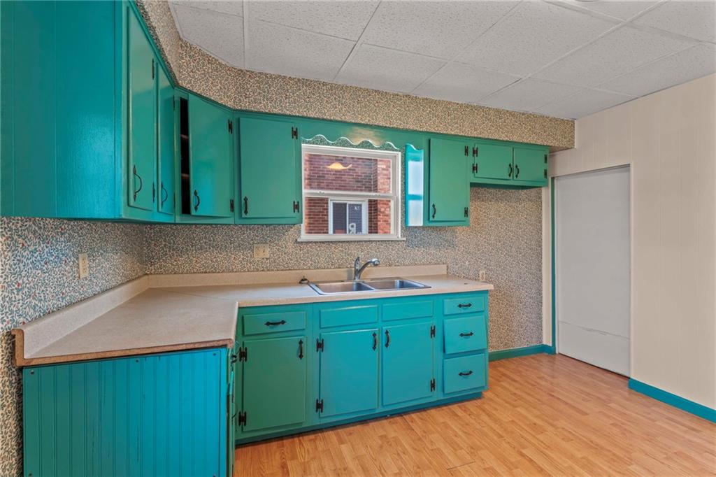 11 Knox Avenue Monessen, PA 15062 - Photo 11 of 25 a kitchen with a sink a microwave oven cabinets and a wooden floors